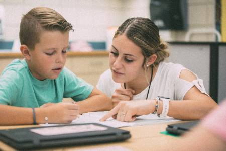 Classroom Instructor working with a student on writing.