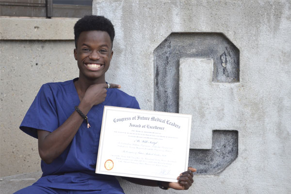 Will Sintyl poses with a certificate from the Congress of Future Medical Leaders.