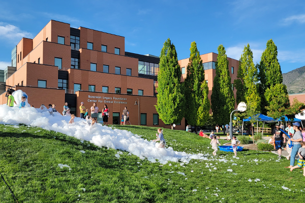 Children play in bubble foam on the hill outside the SCCE