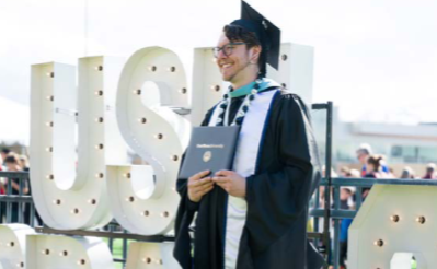 Student in cap and gown at graduation