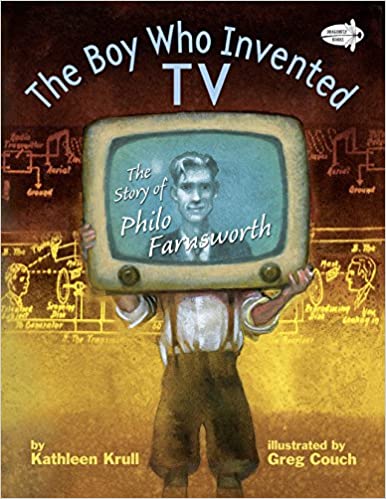 boy holding TV set over his face